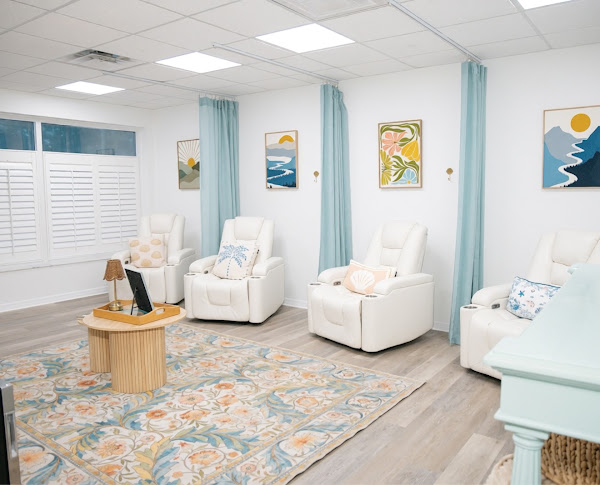 BayouSide's IV lounge with four white recliners and aqua privacy curtains